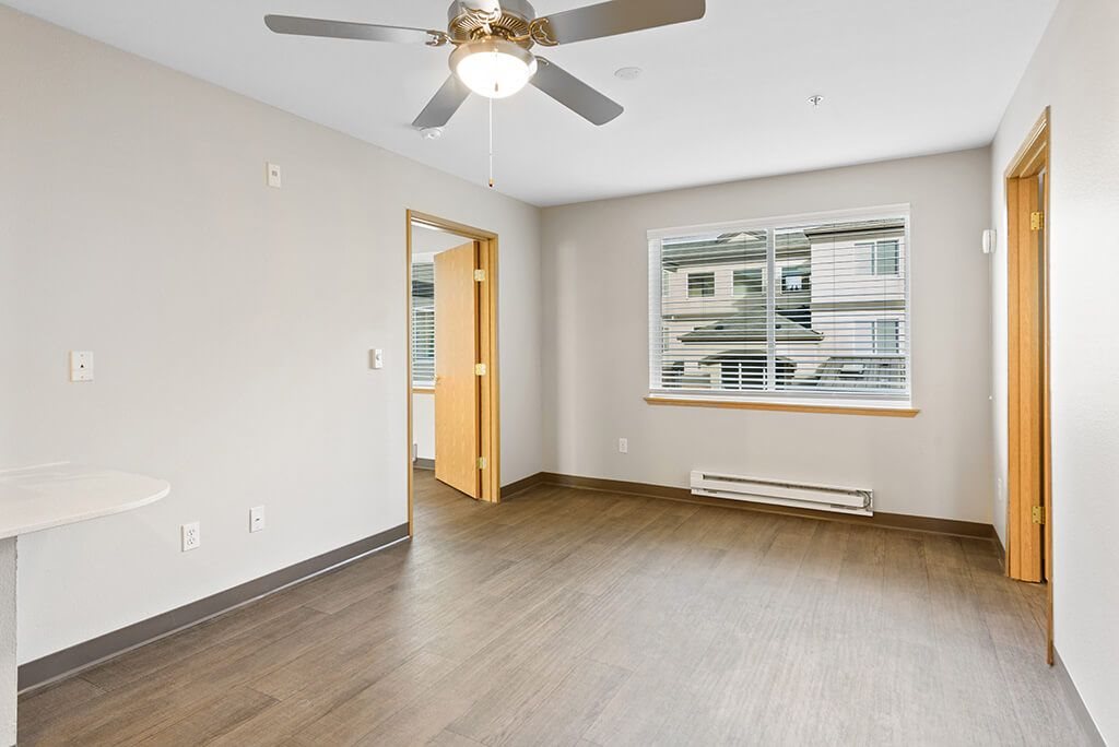 Living room with ceiling fan at Meridian Court Apartments in Federal Way WA